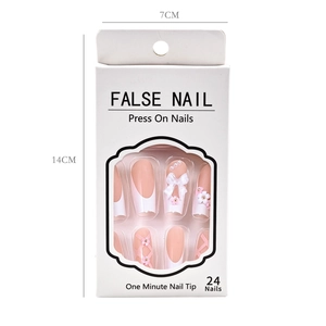 Detail view of pink and white press-on nails with 3D bows and pearls in a white window box