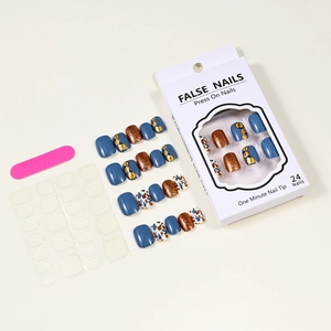 Detail of short blue press-on nails set with pumpkin leaves and floral patterns