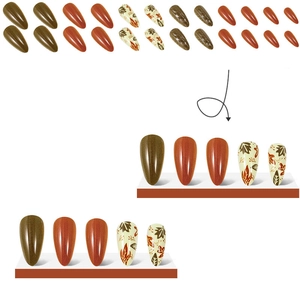 Detail of almond-shaped autumn maple leaf press-on nails with orange and brown colors