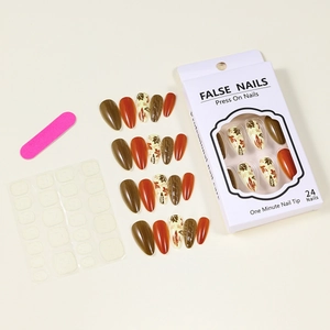 Detail of almond-shaped autumn press-on nails set with maple leaf art and tools