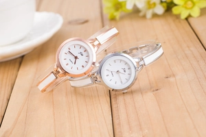Close-up of stylish rose gold and silver quartz watches with ceramic metal bracelet