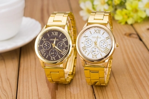 Close-up of Geneva couple watches with gold metal bands on a rustic wooden table