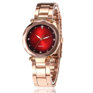 Detail of rose gold quartz watch with red gradient dial and rhinestone markers