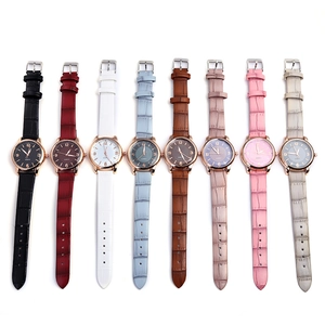 Flat lay of eight colorful quartz watches with crocodile texture straps and rose gold dials