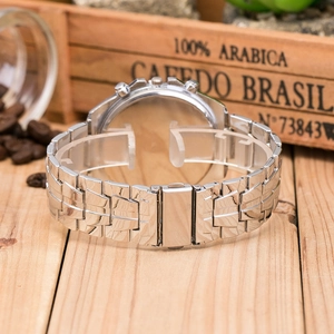 Detail of silver stainless steel watch back and metal strap on wooden surface