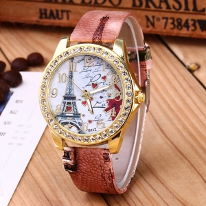 Close-up of pink Eiffel Tower watch with crystal bezel on vintage wood background