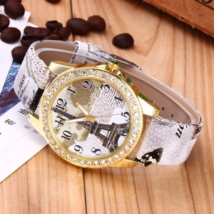 Close-up of vintage quartz watch with Eiffel Tower dial and rhinestone bezel on wood