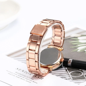 Detailed close-up of rose gold metal watch band with folding clasp and brushed texture