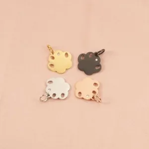 Detail of four colorful paw-shaped pendants with small crystals for jewelry making