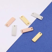 Close-up of rectangular stainless steel bar pendants in gold, silver, and rose gold finishes