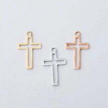 Detailed macro view of hollow cross pendants in gold, silver, and rose gold stainless steel