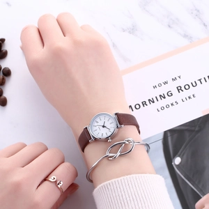 Close-up of women quartz watch with roman numerals, knotted bracelet and ring set
