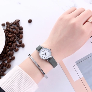Close-up of minimalist women's quartz watch with grey leather strap and diamond bracelet