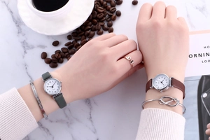 Elegant ladies quartz watches with leather straps on a white marble background