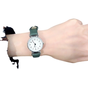Women's quartz watch with green leather strap and white dial featuring Roman numerals