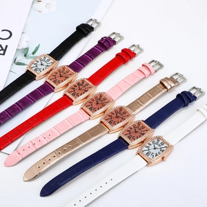 Multiple tonneau-shaped watches with rhinestones and colorful leather straps on white surface