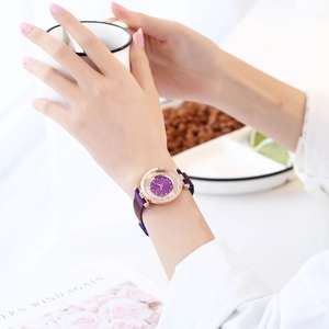 Montre à quartz violette élégante au poignet avec boîtier rose doré et bracelet magnétique