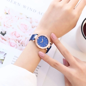 Détail d'une montre quartz pour femme avec cadran bleu étoilé et lunette or rose