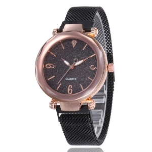 Détail d'une montre à quartz or rose avec cadran étoilé et bracelet magnétique