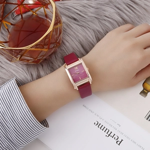 Montre rétro pour femme avec bracelet en cuir bordeaux et boîtier or rose portée au poignet
