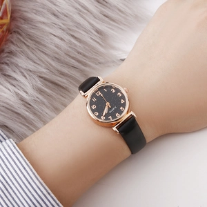 Close-up of women's quartz watch with starry sky dial and black leather strap worn on wrist