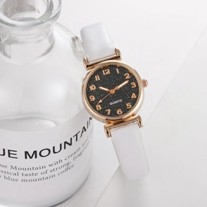 Detailed close-up of a women's starry sky dial watch with a rose gold case and white leather strap