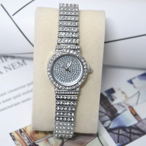 Detail of silver quartz watch with crystal-encrusted bezel and dial on a cushion