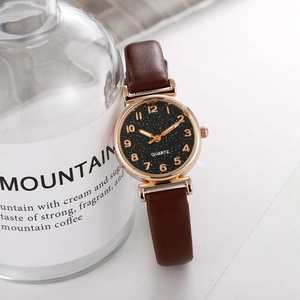 Detailed shot of woman quartz watch with star sky dial and brown leather strap