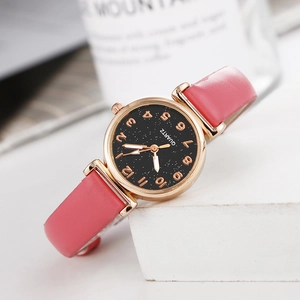 Detail of a pink leather strap watch with rose gold case and black starry dial design