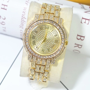 Close-up of iced-out gold watch with rhinestone dial on beige velvet pillow display