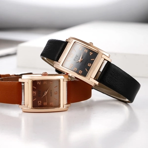 Dettaglio di orologi al quarzo rettangolari con cinturini in pelle marrone e nera e cassa rosa