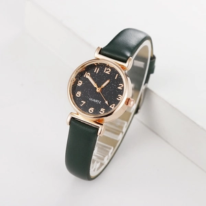 Detail of trendy rose gold women's quartz watch with green leather strap and starry dial