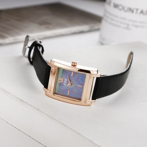 Vue détaillée de la montre carrée en or rose avec cadran marbré et bracelet en cuir noir