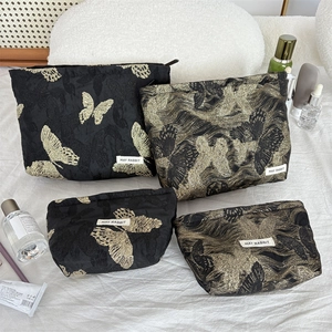 Four-piece makeup bag set featuring gold butterfly jacquard on black polyester fabric