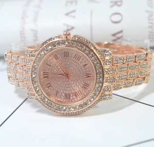 Close-up of rose gold crystal watch featuring a pave diamond dial and Roman numerals