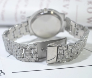 Detail shot of a silver steel watch band with sparkling rhinestones and folding clasp