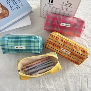 Detailed top view of various colorful checkered fabric pencil cases with metal zippers