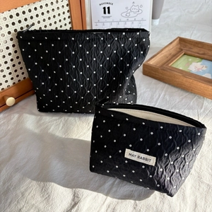 Set of two black polka dot cosmetic bags with textured fabric and top carry handle