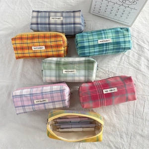 Flat lay of colorful plaid canvas pencil cases with May Rabbit woven labels