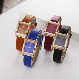 Gros plan de quatre montres à quartz carrées avec bracelets en cuir et boîtiers or rose