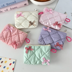 Detailed top view of five quilted bow cosmetic bags in white pink purple and mint green