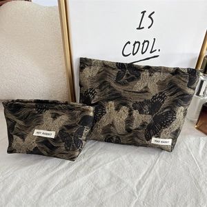Detail of butterfly jacquard makeup bags with gold embroidery and May Rabbit logo