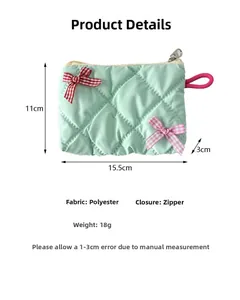 Detail of light green quilted cosmetic bag with pink bow showing polyester material and size