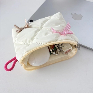 Macro view of white quilted cosmetic bag showing interior storage for makeup and accessories