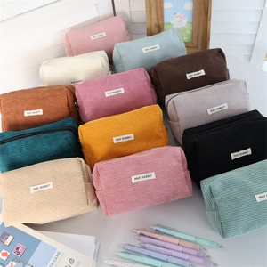 Portable corduroy pencil case with large capacity shown in multiple colors on a white desk