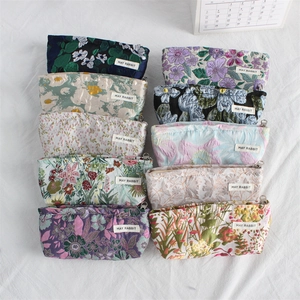 Detailed view of ten floral canvas makeup pouches with vintage botanical embroidery patterns