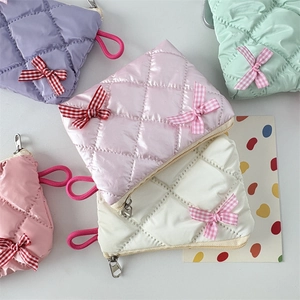 Quilted cosmetic bags with bows in purple, green, pink, and white glossy nylon fabric