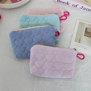 Detailed view of quilted heart pattern pouches in pink, light blue, and striped designs