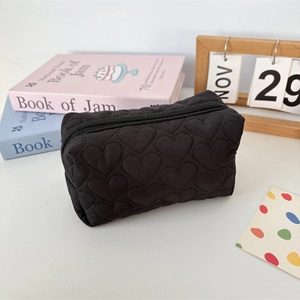 Detail of heart-quilted texture on soft black large capacity cosmetic storage bag