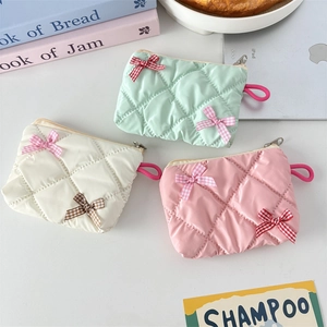 Quilted bow makeup bags in mint, white and pink with glossy finish and wrist straps
